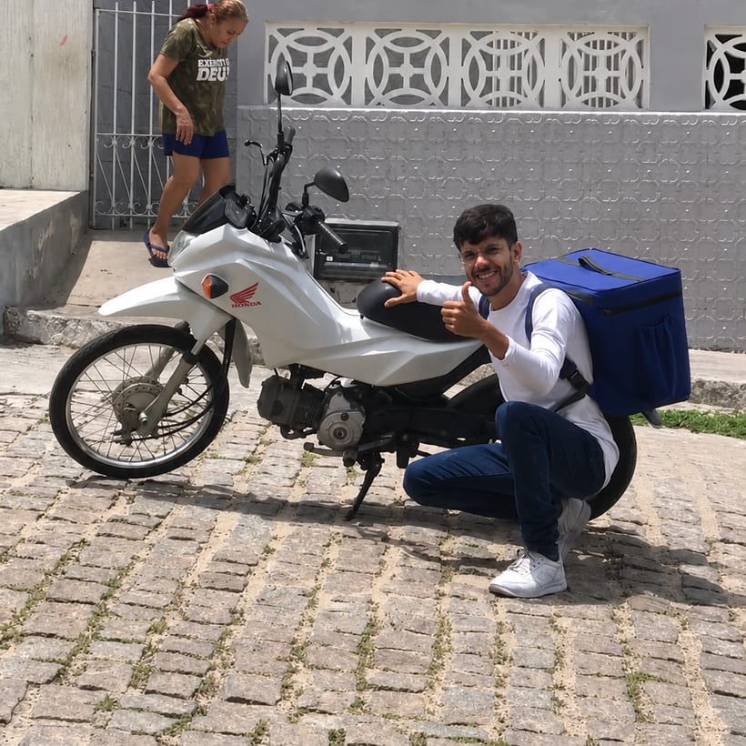 Victor entregando de moto, com a bag de entrega